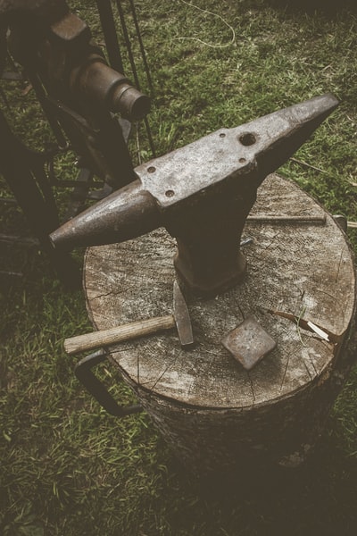 用锤子切割原木上的金属砧
